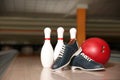 Shoes, pins and ball on bowling lane in club Royalty Free Stock Photo