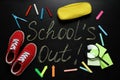 Shoes, stationery and text SCHOOL`S OUT written on blackboard, flat lay. Summer holidays Royalty Free Stock Photo