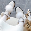 Shoes woman. beautiful boots on women`s legs. white shoes close-up outdoors. happy woman
