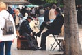 Shoeshine man unidentified working on client's shoe on a street in Lisbon