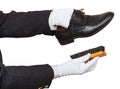 Shoeshiner in white gloves cleaning black shoes Royalty Free Stock Photo