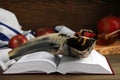 Shofar and open Torah on wooden table, closeup. Rosh Hashanah celebration