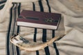 A shofar is placed on a tallit next to a close Torah study book. Before the Jewish holidays on the month