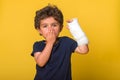 Shoked surprised and sad little boy in a cast. Child with a broken arm. Funny kindergarten kid after accident isolated Royalty Free Stock Photo