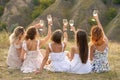Shoot from back. The company of gorgeous female friends having fun, cheers and drink wine, and enjoy hills landscape picnic Royalty Free Stock Photo