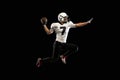 Portrait young American football player, athlete in black white sports uniform training isolated on dark studio Royalty Free Stock Photo