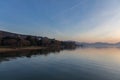 A shoot of a sunset over a lake, with beautiful warm colors and many diagonal lines created by clouds and water waves