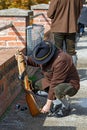 Shooter in national costume is charging the handgun. Graz, Austria.