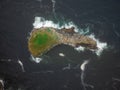 Shooting from the air. A small stone island of a bizarre shape in the form of a fish, overgrown with green moss in the middle of Royalty Free Stock Photo