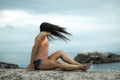 Woman flicking her hair on a rock at sunset on Bakovern Beach, Cape Town.