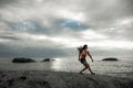 Woman landing on a rock at sunset on Bakovern Beach, Cape Town.