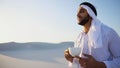 Portrait of handsome young Arabian Sheikh who drinks from cup of Royalty Free Stock Photo