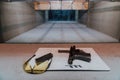 Shooting equipment in front of the target. Pistol, goggles and headphones on the table of a modern shooting range Royalty Free Stock Photo