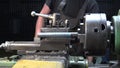 Shooting of a man working with metal details on a lathe