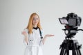 Shooting for a medical video blog. A female doctor smiles and records a training video for her subscribers and patients