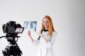 Shooting for a medical video blog. A female doctor smiles and records a training video for her subscribers and patients