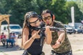 Shooting range concept. Private shooting lessons with an instructor. Medium outdoor shot of a powerful long-haired woman