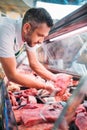 shop assistant in apron assorting fresh raw meat