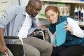 shop assistant helping handicaped man in hardware store Royalty Free Stock Photo