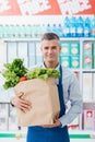 Shop assistant holding a grocery bag Royalty Free Stock Photo