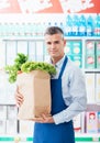 Shop assistant holding a grocery bag Royalty Free Stock Photo