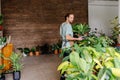 Shop assistant holding terrarium in indoor potted plant store, small business concept.