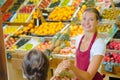 Shop assistant serving customer in grocers