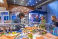 Shop assistant serving customers in a seafood shop in Melbourne