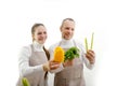 Shop assistant in supermarket re-stocking fresh vegetables into boxes adult man and young woman in an apron on a white Royalty Free Stock Photo