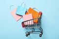 Shop cart with paper bags on blue background Royalty Free Stock Photo