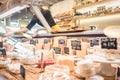 Shop clerk woman sorting cheese in the supermarket display Royalty Free Stock Photo