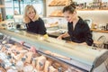Shop clerk women at the cheese counter in a supermarket Royalty Free Stock Photo