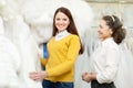 Shop consultant helps bride chooses bridal clothes Royalty Free Stock Photo