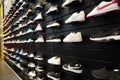 Shop display of a lot of Sports shoes on a wall. A view of a wall of shoes inside the store. Modern new stylish sneakers running Royalty Free Stock Photo