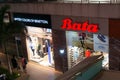 Shop exterior of a bata store in a busy shopping mall at night