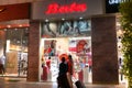 Shop exterior of a bata store in a busy shopping mall at night