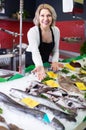 Shop female stuff selling chilled on ice fish in supermarket