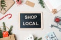 Shop Local text written on blackboard. Flat lay with Support Local Business quote, Christmas decoration and shopping bag Royalty Free Stock Photo