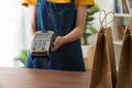 Shop owner holds a card swipe machine for customers to pay