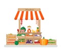 Shop tent with a white and red stripe. Market counter, wooden boxes, fruits and vegetables, scales.