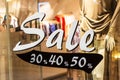 Shop window of the clothing store with big white word sale in the shopping mall. Royalty Free Stock Photo