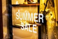 Shop window of the clothing store with big white words summer sale in the shopping mall. Royalty Free Stock Photo