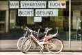 Shop window with german notice : Wir vermissen euch..bleibt gesund/ We miss you. Stay healthy. There are two bicycles in front of