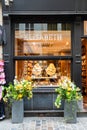 A shop window with vase of meringues in it.