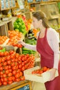 Shop worker carrying crate tomatoes