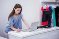 Shop worker using laptop by the till Royalty Free Stock Photo