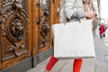 Shopaholic beautiful happy woman goes shopping in the city. Young girl in red pants and a lot of grey paper bags her Royalty Free Stock Photo