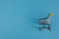 Shopaholic. Buyer. Shopping concept. Close-up. Isolated shopping trolley on a blue background. Copy space