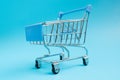 Shopaholic. Buyer. Shopping concept. Close-up. Isolated shopping trolley on a blue background. Copy space.