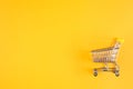 Shopaholic. Buyer. Shopping concept. Close-up. Isolated shopping trolley on a yellow background. Copy space